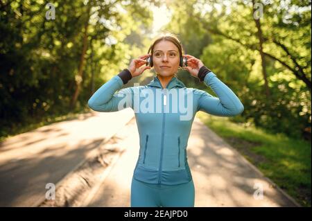 Training in park, woman listens to music Stock Photo