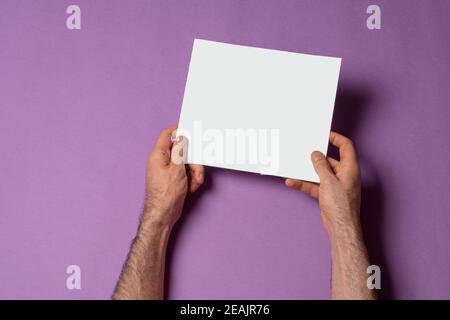 Male hands holding a square proportion catalog with blank cover mock-up series 258 Stock Photo