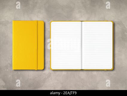 Yellow closed and open lined notebooks on concrete background Stock Photo