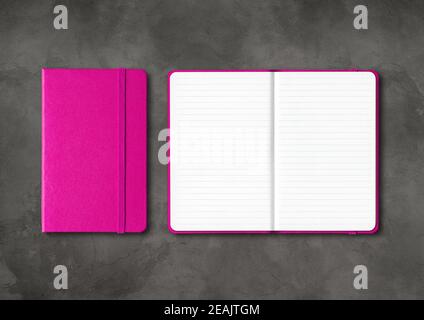 Pink closed and open lined notebooks on dark concrete background Stock Photo