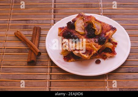 Homemade cookies with fruit in a white saucer on a bamboo mat, close up Stock Photo