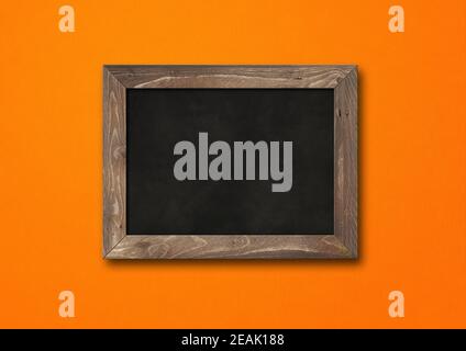 Old rustic black board isolated on orange background Stock Photo