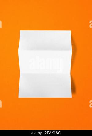 Blank folded White A4 paper sheet mockup template on orange background Stock Photo