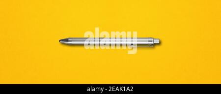 Metal pen isolated on yellow background Stock Photo