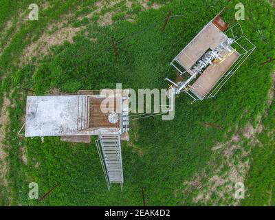 Equipment of an oil well. A tank with methanol near the oil well. Shutoff valves and service equipment Stock Photo