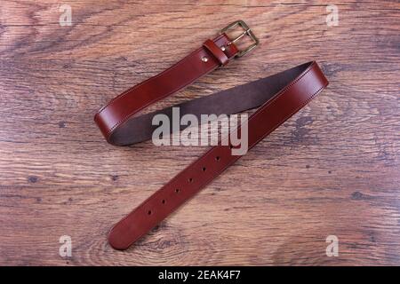 Brown leather belt on a wood background Stock Photo