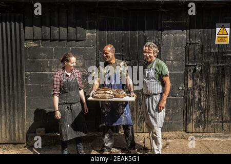 GREAT BRITAIN / England / Hertfordshire / Bakers holding freshly baked loaves of bread.. Stock Photo