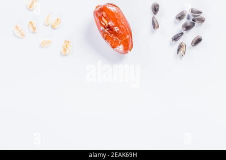 Sunflower seeds, oats and dried  dactyl on white background with copy space. Stock Photo