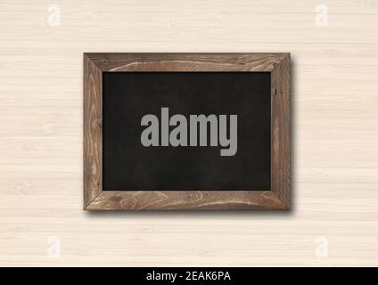 Old rustic black board isolated on a wooden background Stock Photo