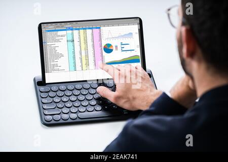 Analyst Using Spreadsheet Report On Tablet Stock Photo