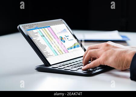 Analyst Using Spreadsheet Report On Tablet Stock Photo