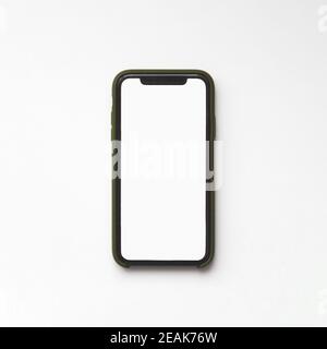 Minsk, Belarus - November 02, 2020: iPhone 11 with blank white screen in green protective case on white background, top view Stock Photo