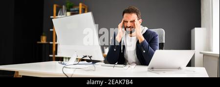 Man With Migraine From Computer Work. Bored Stock Photo