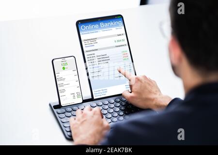 Young Businessman Looking At Invoice While Doing Online Banking Stock Photo