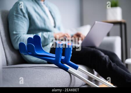 Injured Man With Broken Leg And Crutches Stock Photo