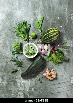 Greens and green vegetables on gray background Stock Photo