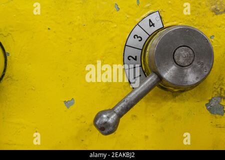 Old yellow lathe machine with a lot of handles. Stock Photo