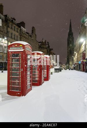 Edinburgh, Scotland, UK. 10 Feb 2021. Big freeze continues in the UK with heavy overnight and morning snow in the city. Pic; Three telephone boxes on an  empty Royal Mile in early morning snow.  Iain Masterton/Alamy Live news Stock Photo
