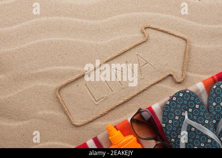 Lima  pointer and beach accessories lying on the sand Stock Photo