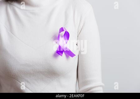 Young woman stick purple ribbon on the chest Stock Photo