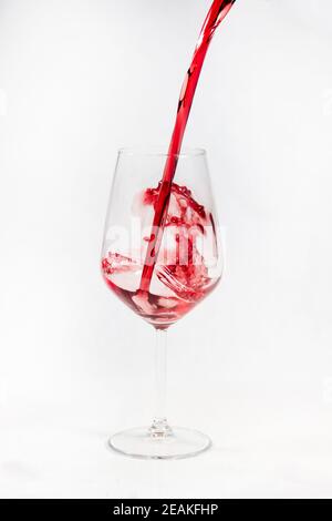 Red wine poured in a glass isolated on white.