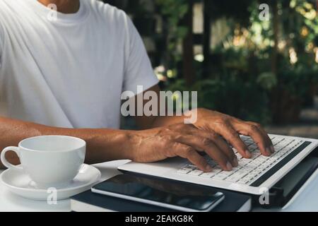 A man working at home and using laptop on the table. Technology and business concept. Stock Photo