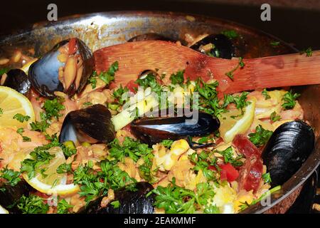 Closeup of seafood paella with lemons, mussels, and rice Stock Photo