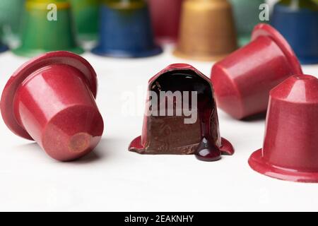 Chocolate candies in the shape of a coffee capsule with red wine filling. Stock Photo