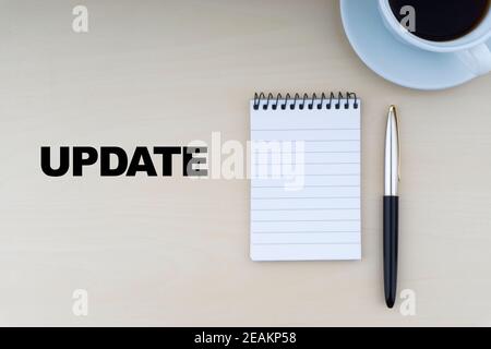 UPDATE text with fountain pen, notepad and cup of coffee on wooden background Stock Photo
