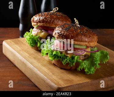 burger with fried beef cutlet and onions, crispy white wheat flour bun with sesame seeds Stock Photo