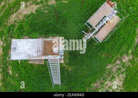 Equipment of an oil well. A tank with methanol near the oil well. Shutoff valves and service equipment Stock Photo