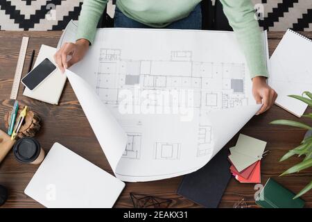 top view of african american architect working with blueprint at home Stock Photo