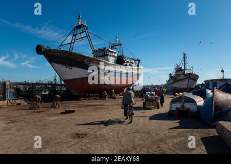 Essaouira, Morocco - April 15, 2016: Fisherman in the harbor at the city of Essaouira, with the the traditional fishing boats, in the Atlantic Coast o Stock Photo