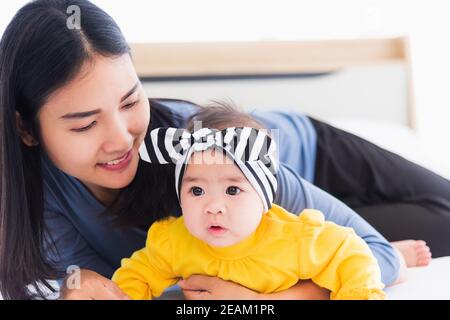 mother playing and smiling together with his newborn little baby Stock Photo