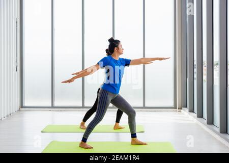 Two Asian women sporty attractive people practicing yoga lesson together Stock Photo