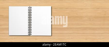 Blank open spiral notebook isolated on wooden banner Stock Photo