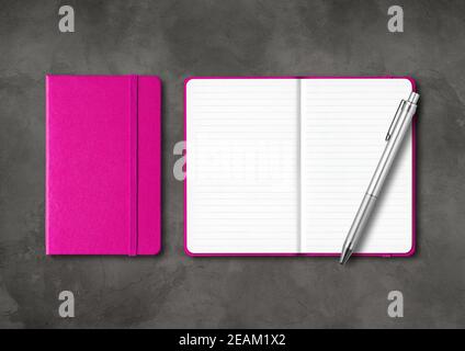 Pink closed and open lined notebooks with a pen on dark concrete background Stock Photo