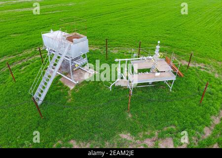 Equipment of an oil well. A tank with methanol near the oil well. Shutoff valves and service equipment Stock Photo