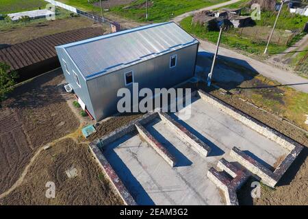 Buildings on the site. Hangar from metal profile, corrugated. Th Stock Photo