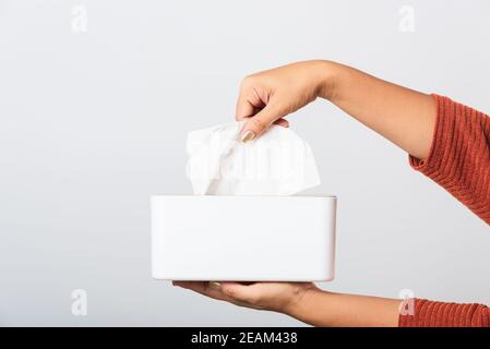 Hand taking pulling white facial tissue out of from a white box