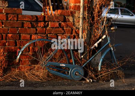 PARMA, ITALY - Feb 01, 2021: orizontal background bike abandoned near red wall objects Stock Photo
