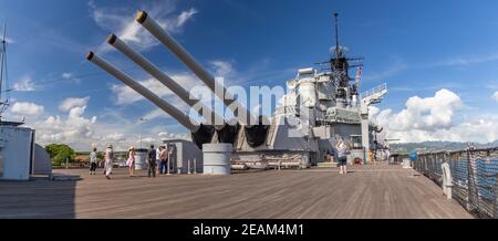 Pearl Harbor, Hawaii, USA - September 24, 2018: Panoramic shot of huge cannons and deck of USS Missouri docked in Pearl Harbor. Deck full of tourists. Stock Photo