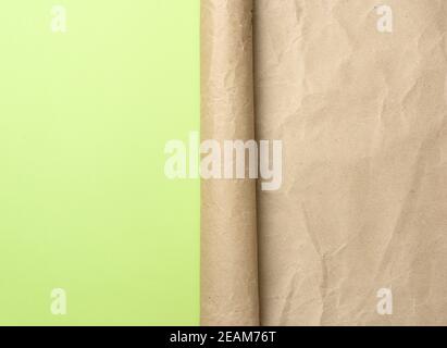 folded corner of a roll of brown paper on a green background Stock Photo
