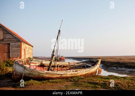 Old barn and boat at Thornham old harbour, Norfolk, England Stock Photo