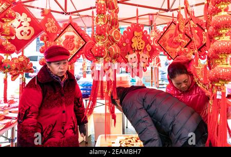 (210210) -- SHAOYANG, Feb. 10, 2021 (Xinhua) -- Customers purchase decorations for the upcoming Chinese Lunar New Year in Taohong Town of Longhui County in Shaoyang City, central China's Hunan Province, Feb. 10, 2021. (Photo by Fan Hui/Xinhua) Stock Photo