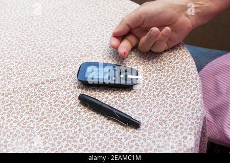 Man using glucometer checking blood sugar. Diabetes and glycemic concept. Stock Photo