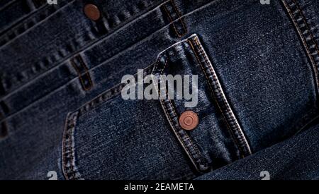 Selective focus on denim jean jacket pocket in clothes shop. Denim jacket pocket and button texture. Textile industry. Jeans fashion and shopping concept. Clothing concept. Denim jacket for sale. Stock Photo