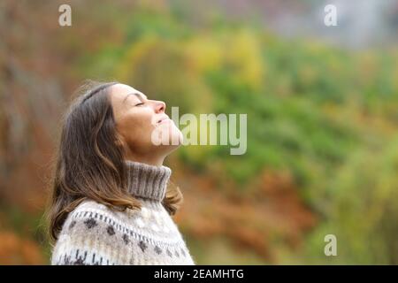 Middle aged woman breathing fresh air in a forest Stock Photo