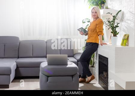 Middle-aged woman reading a message, e-book or information on her tablet computer with a look of excited anticipation at home Stock Photo