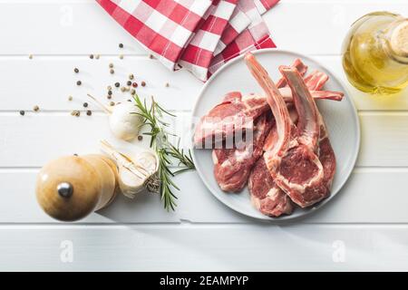 Slices raw lamb chops on plate Stock Photo